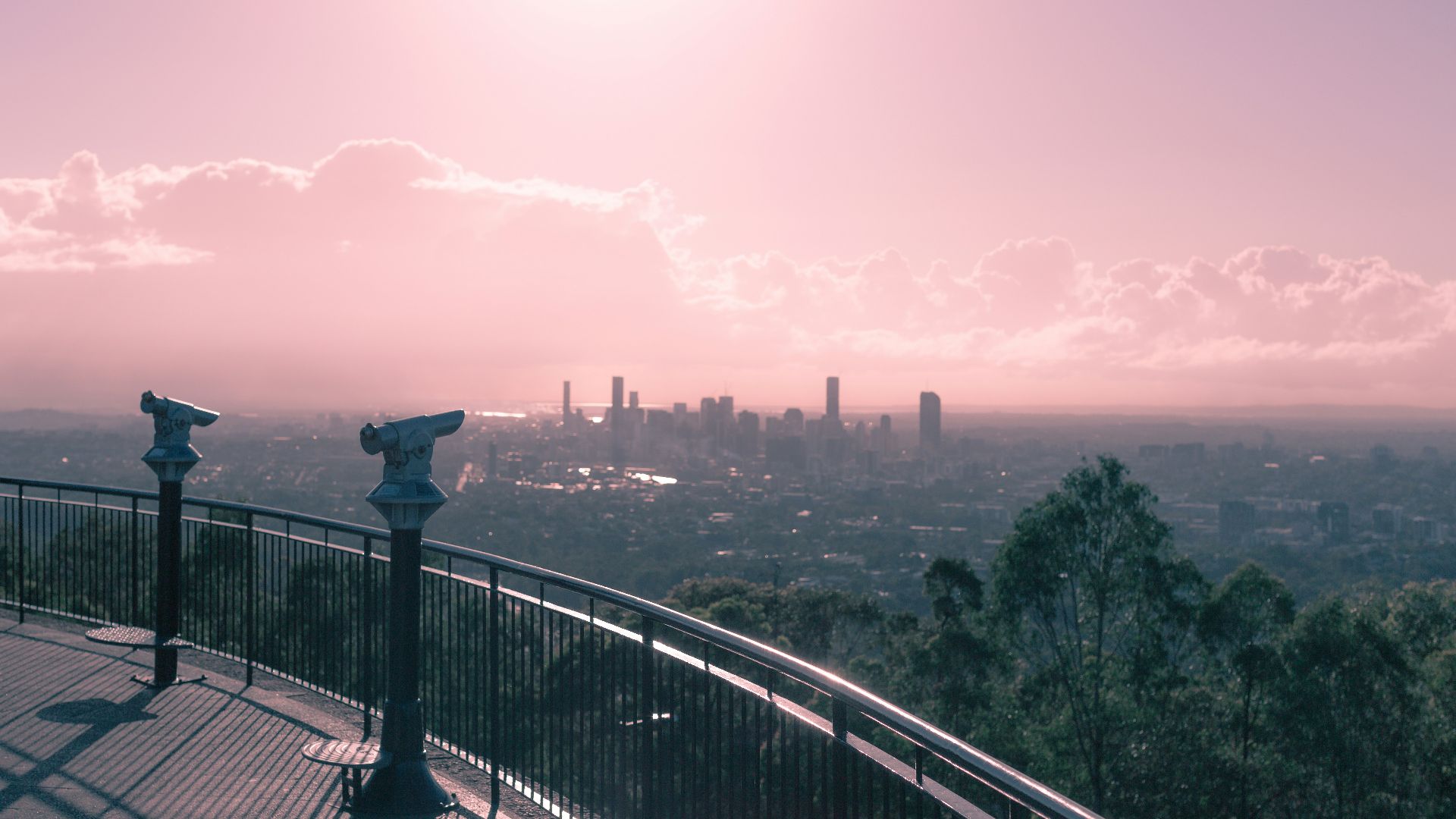 black metal railings near green trees and body of water during daytime