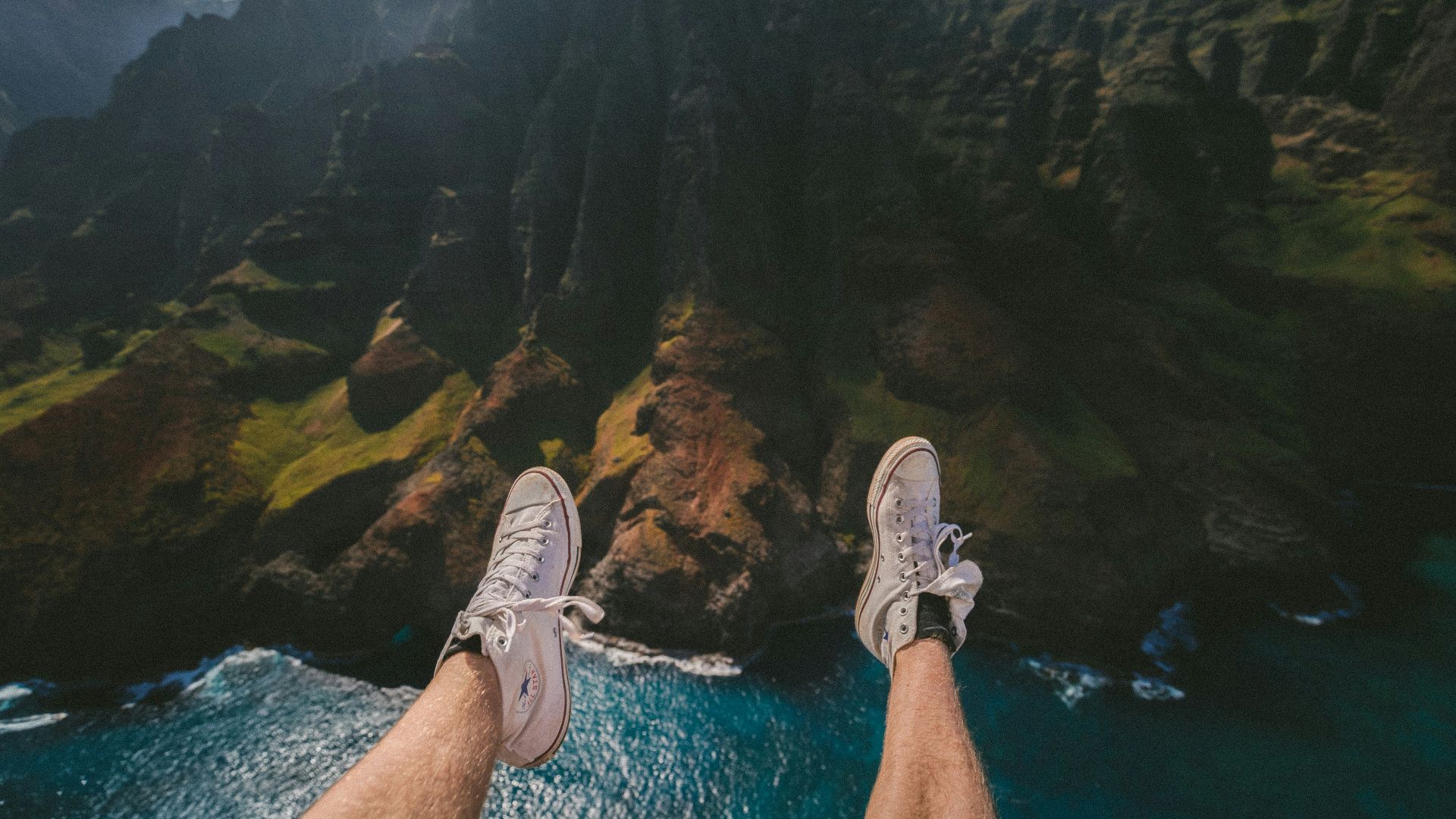 person above mountain and body of water