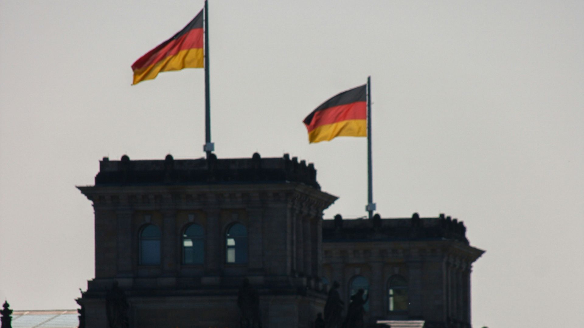 two flags flying on top of a building