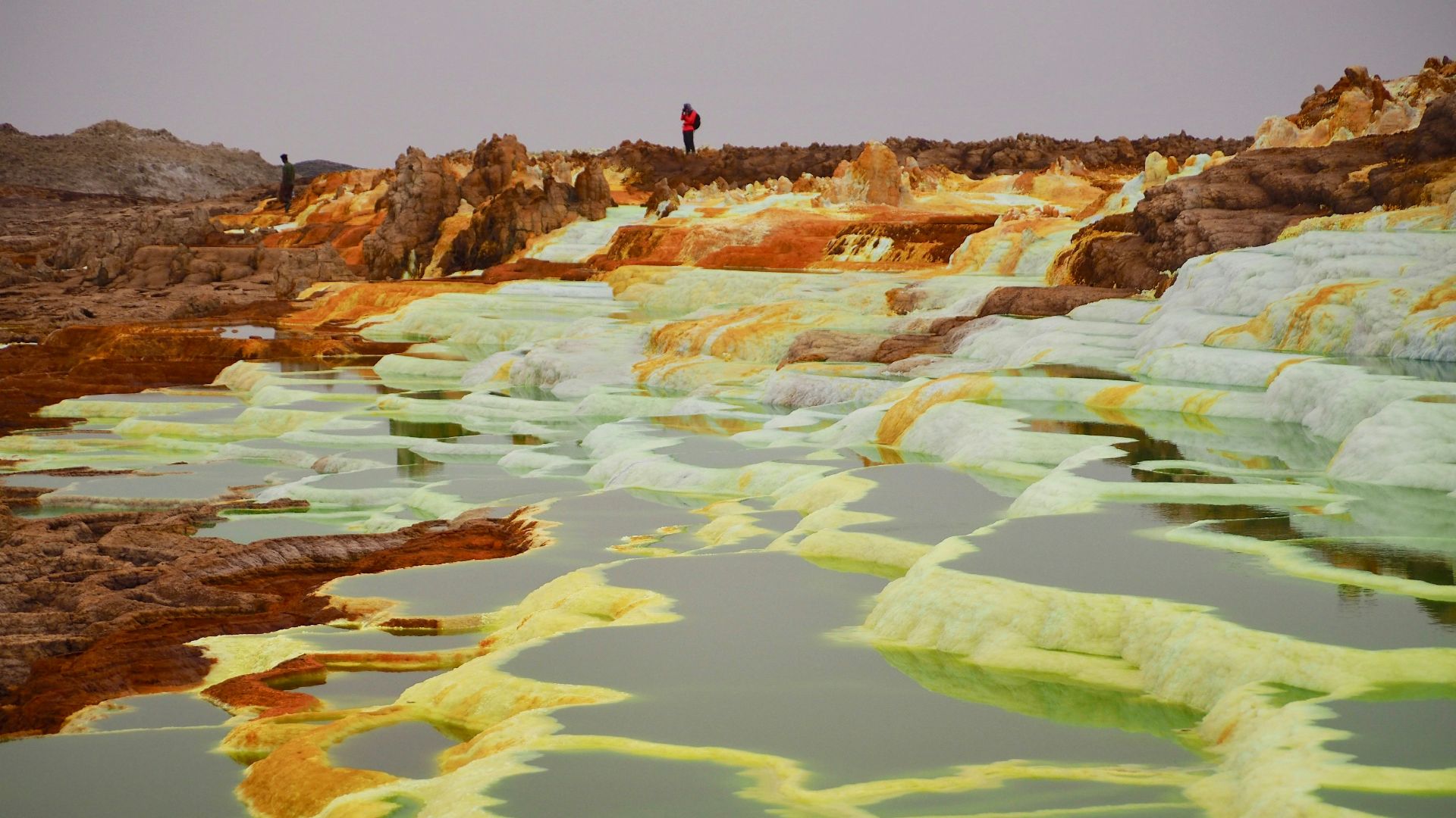 two people standing on top of hill
