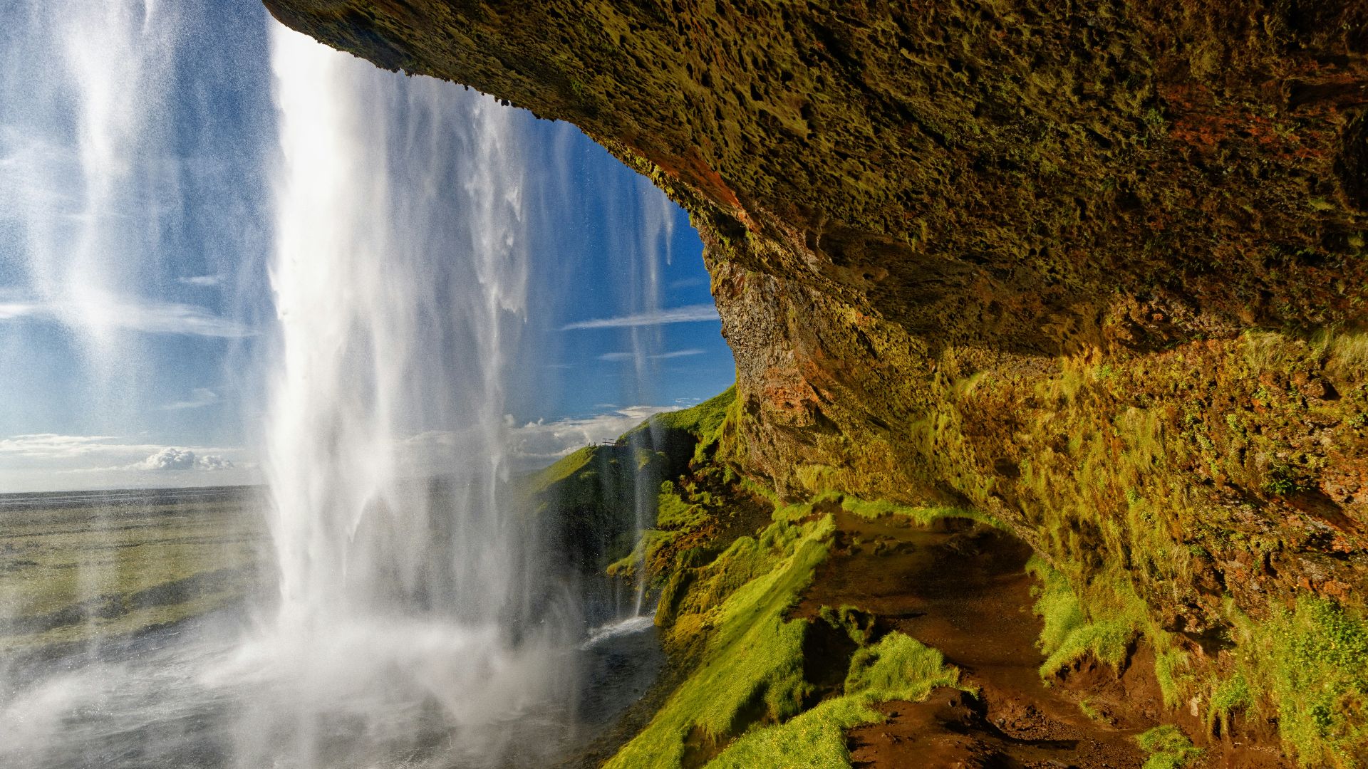 water falls in brown rocky mountain during daytime