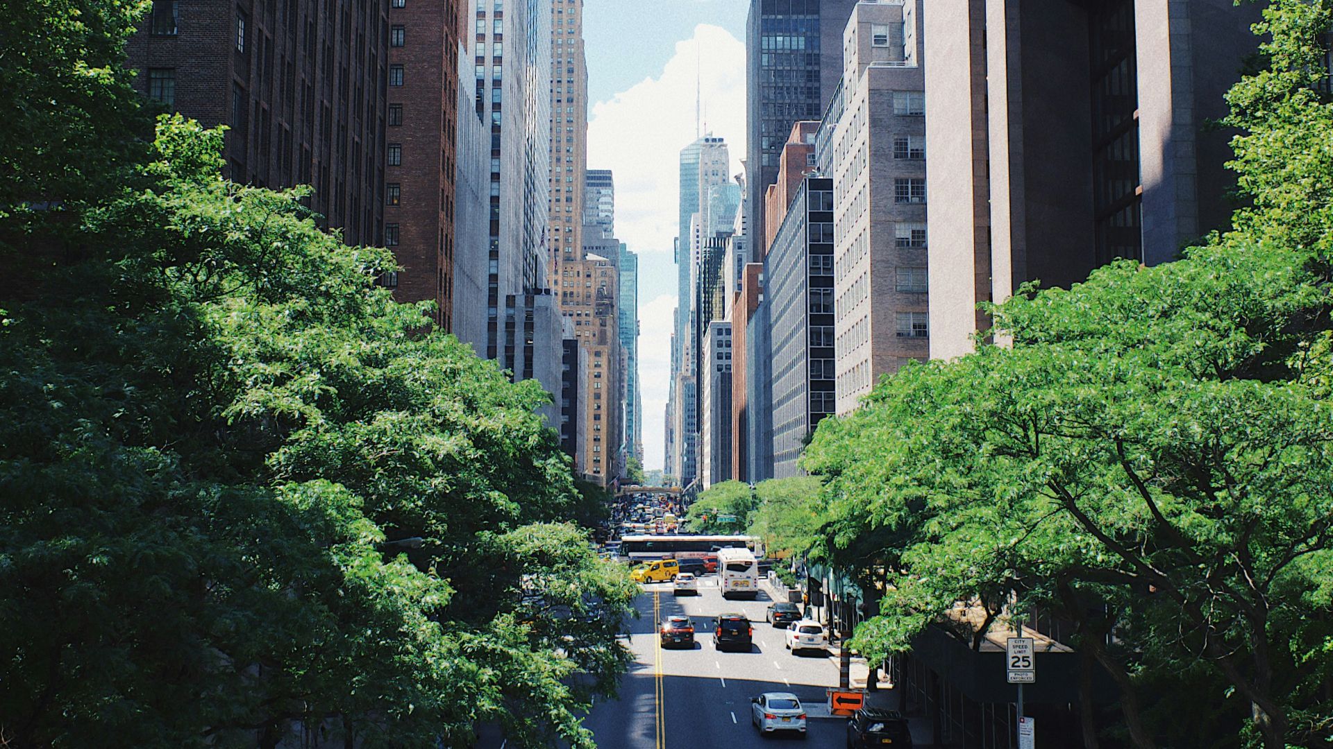 yellow car running on the street between the building during daytime