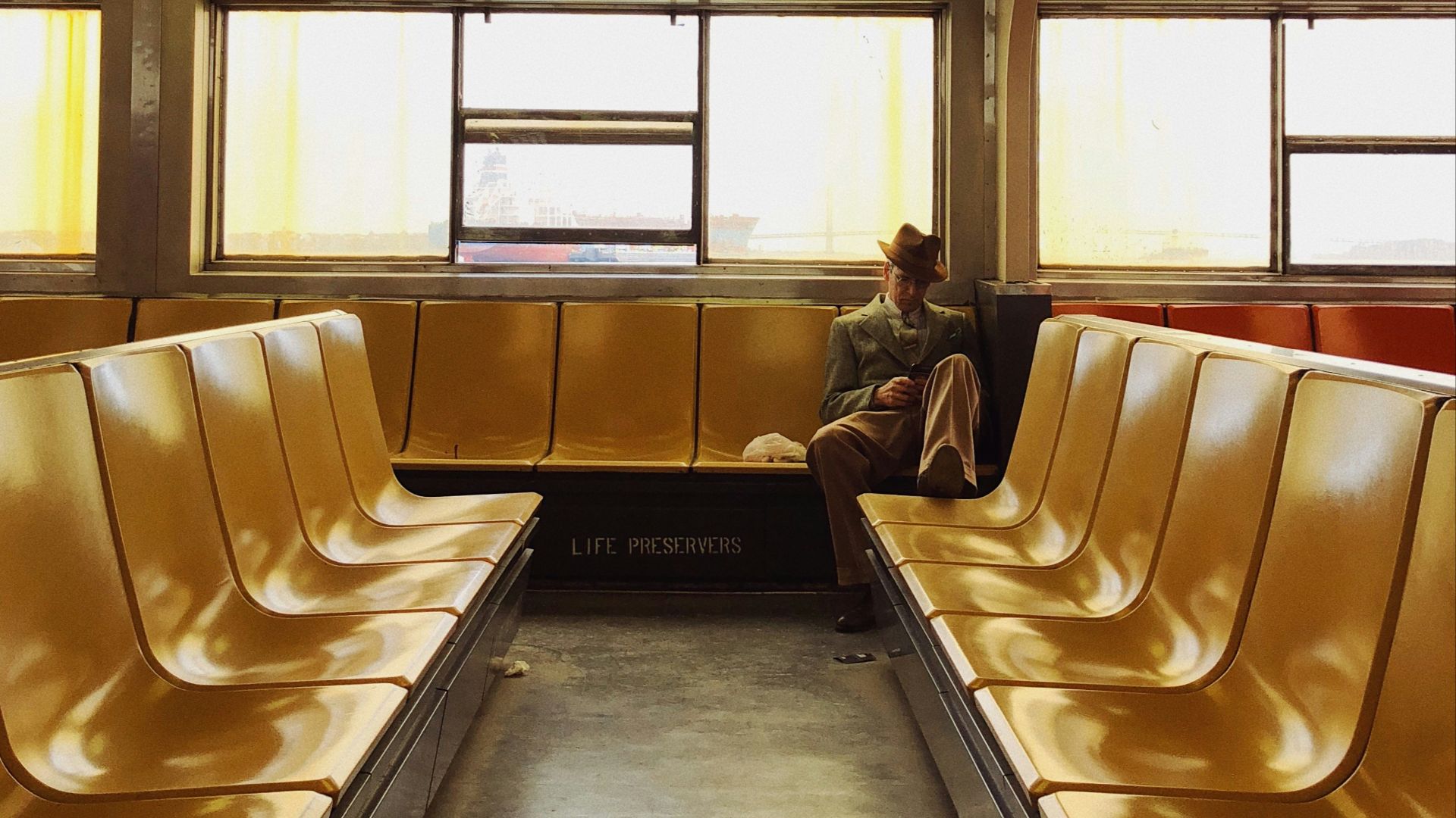 man in black jacket sitting on white leather chair