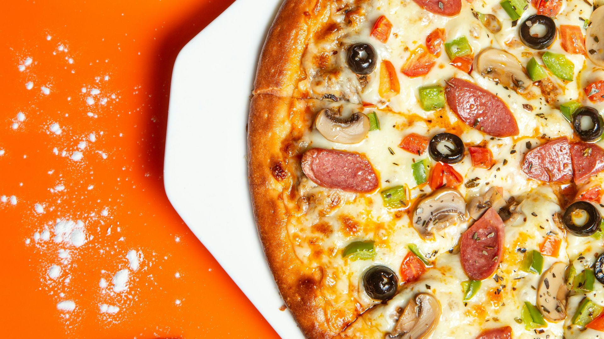 pizza with pepperoni and cheese on orange table