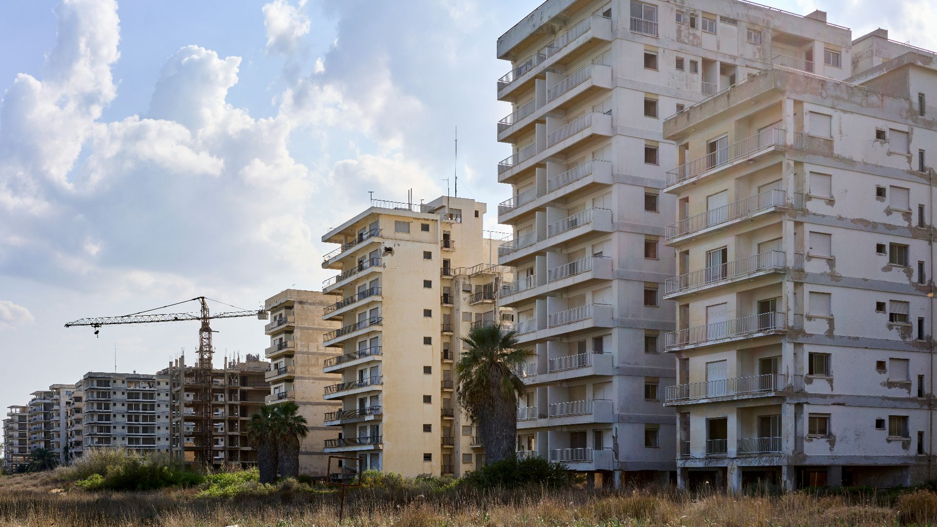 a tall white building sitting on top of a sandy beach