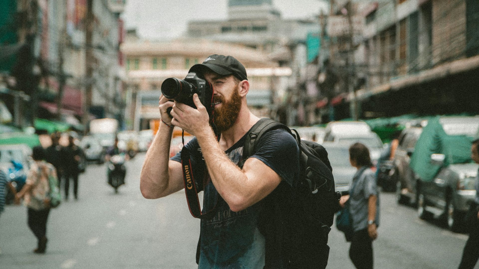 shallow focus photography of man using a DSLR camera