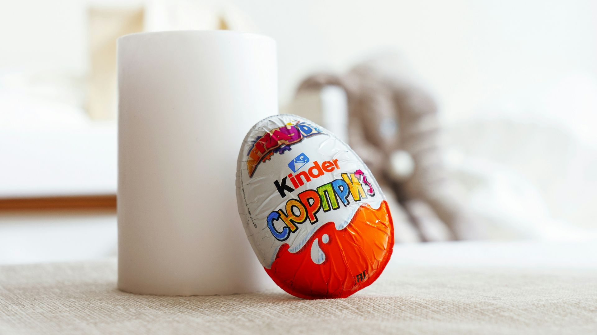 a white cup sitting next to an orange and white egg