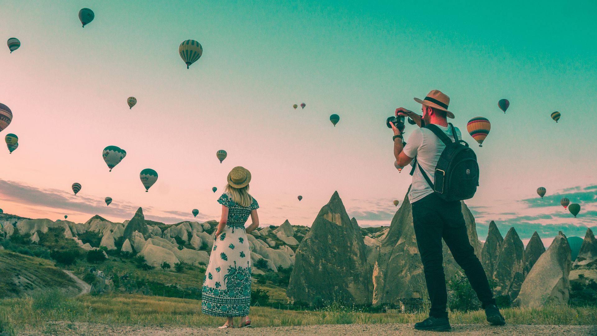 man taking photo of hot air balloons