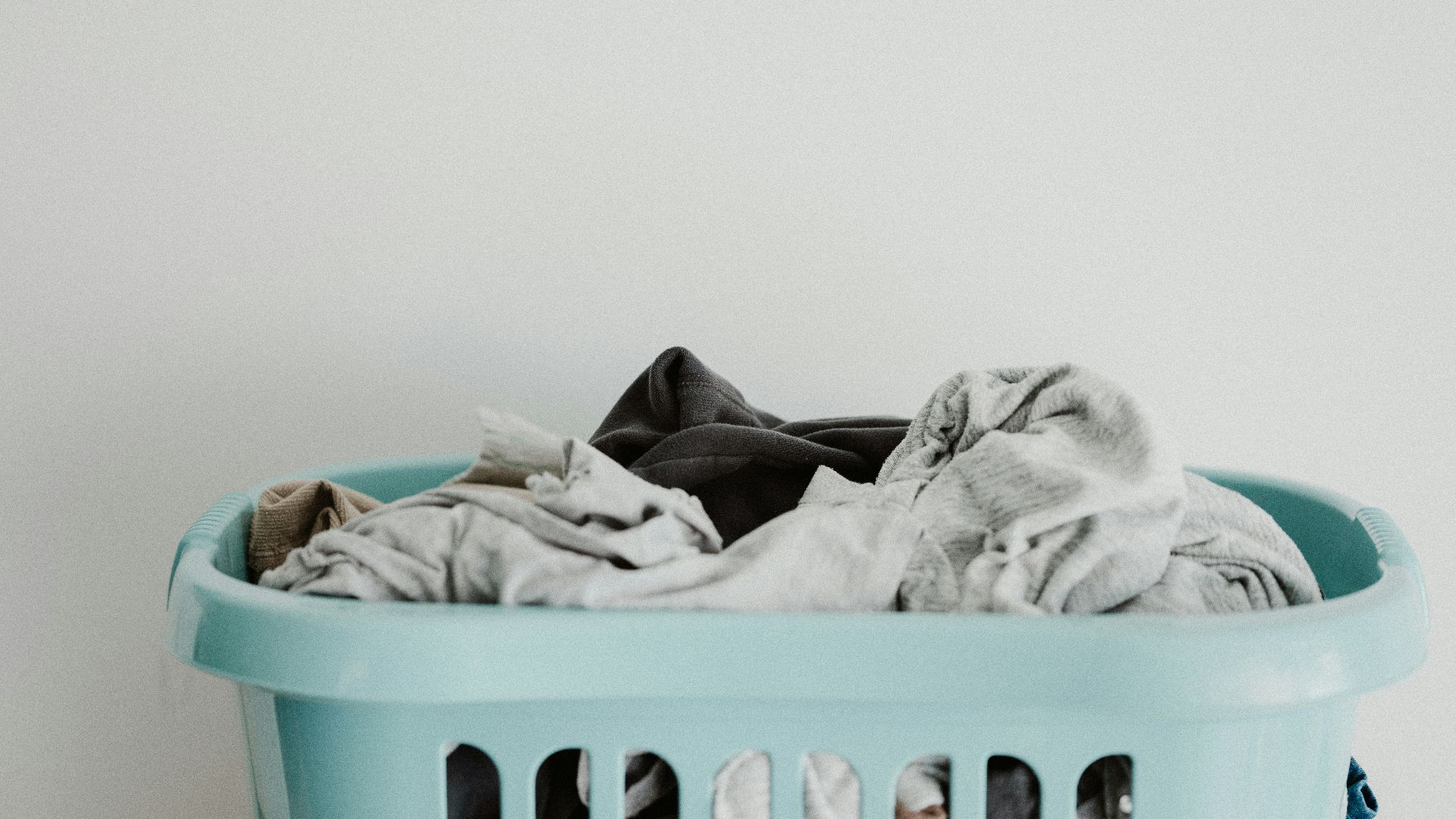 white textile on blue plastic laundry basket