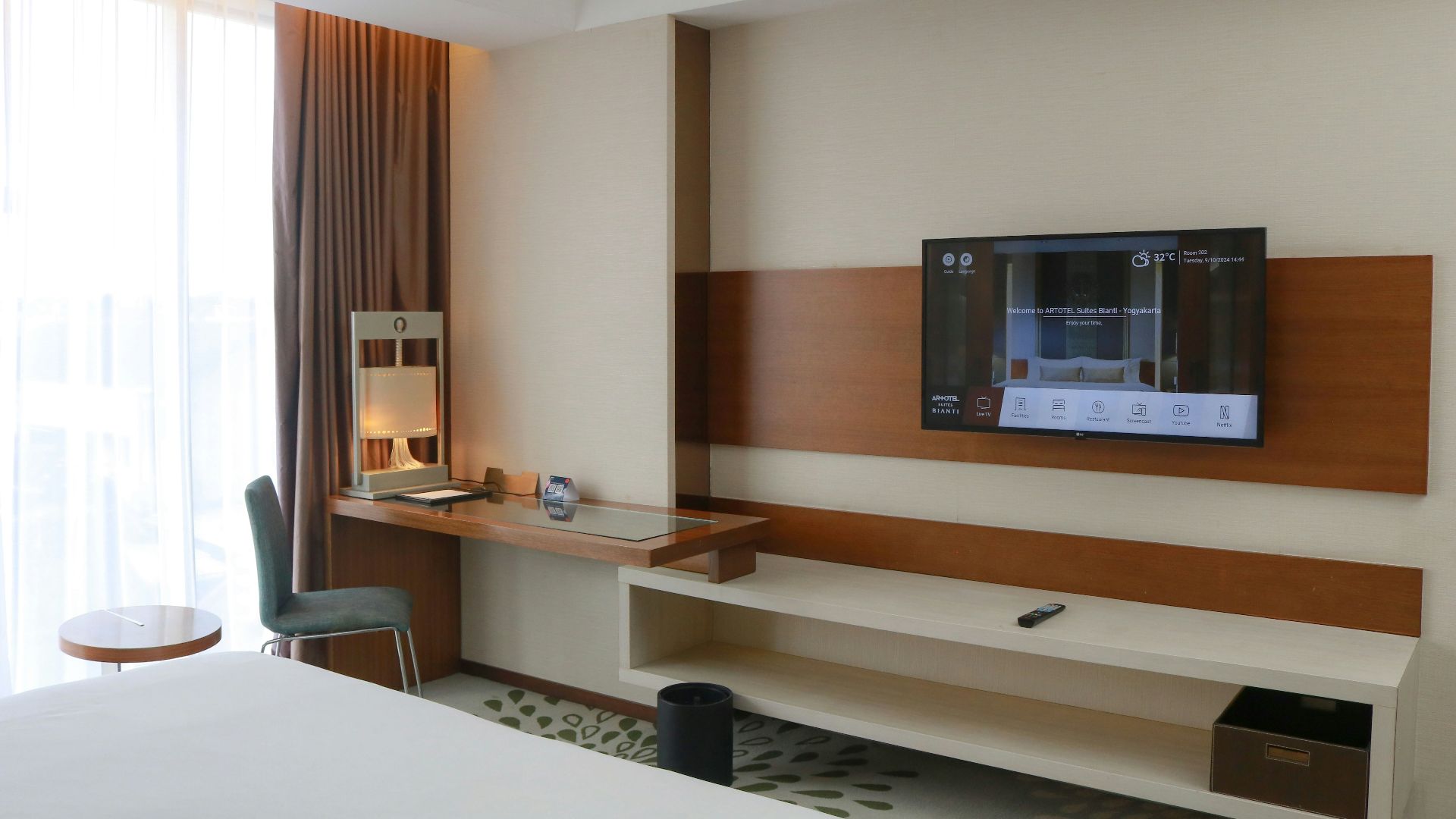 A hotel room with a flat screen TV on the wall
