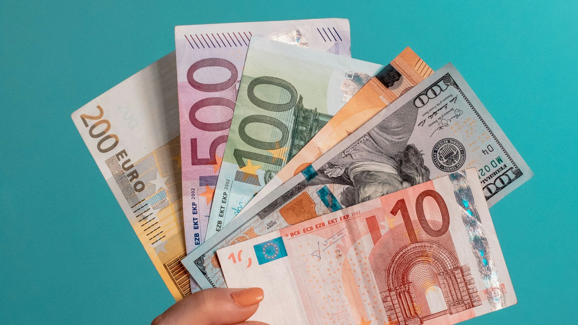 person holding fan of 100 us dollar bill