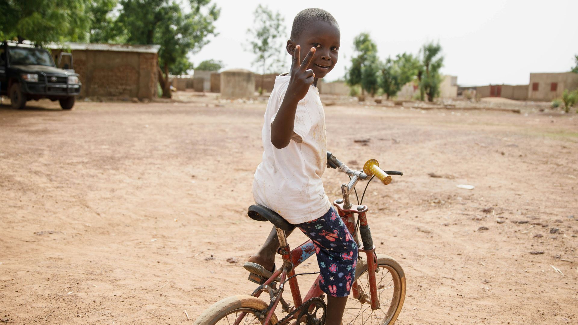 girl in white shirt riding on bicycle during daytime
