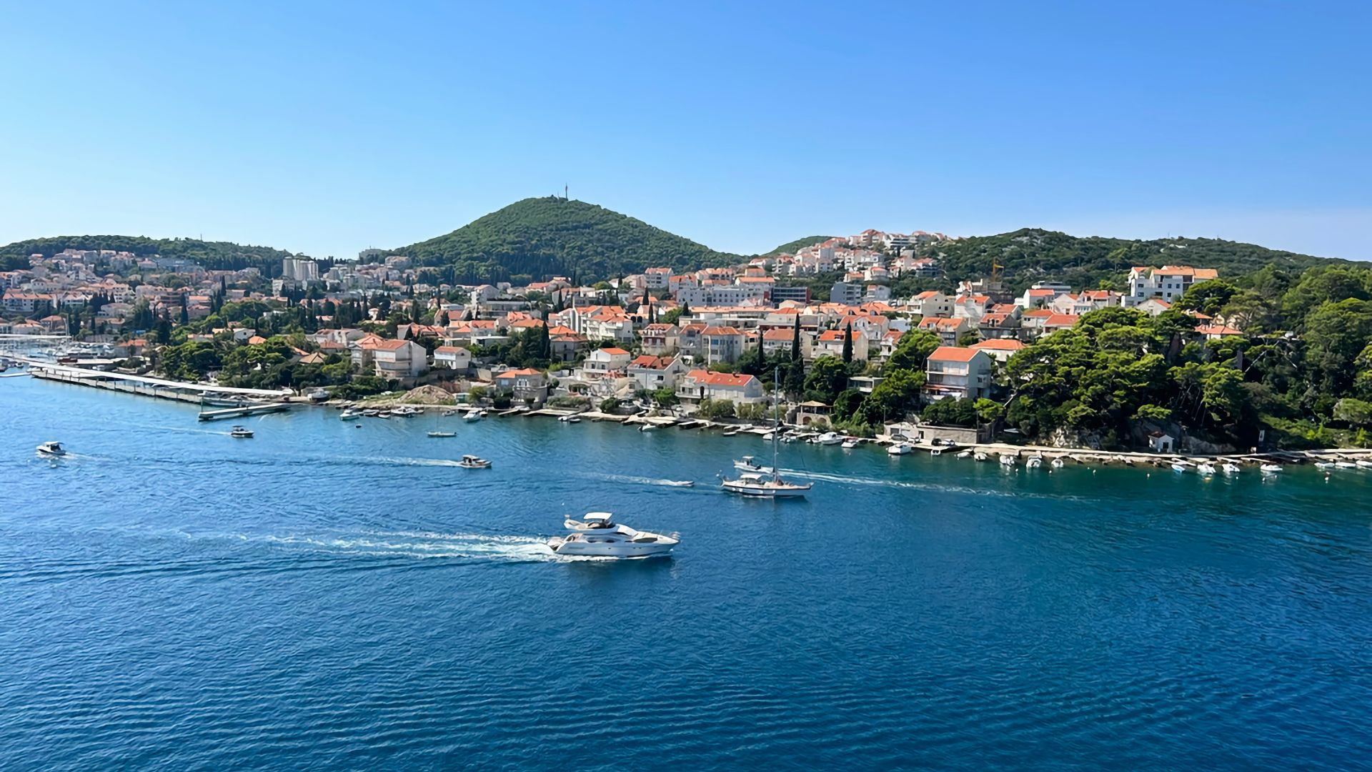 a boat traveling on a body of water near a city
