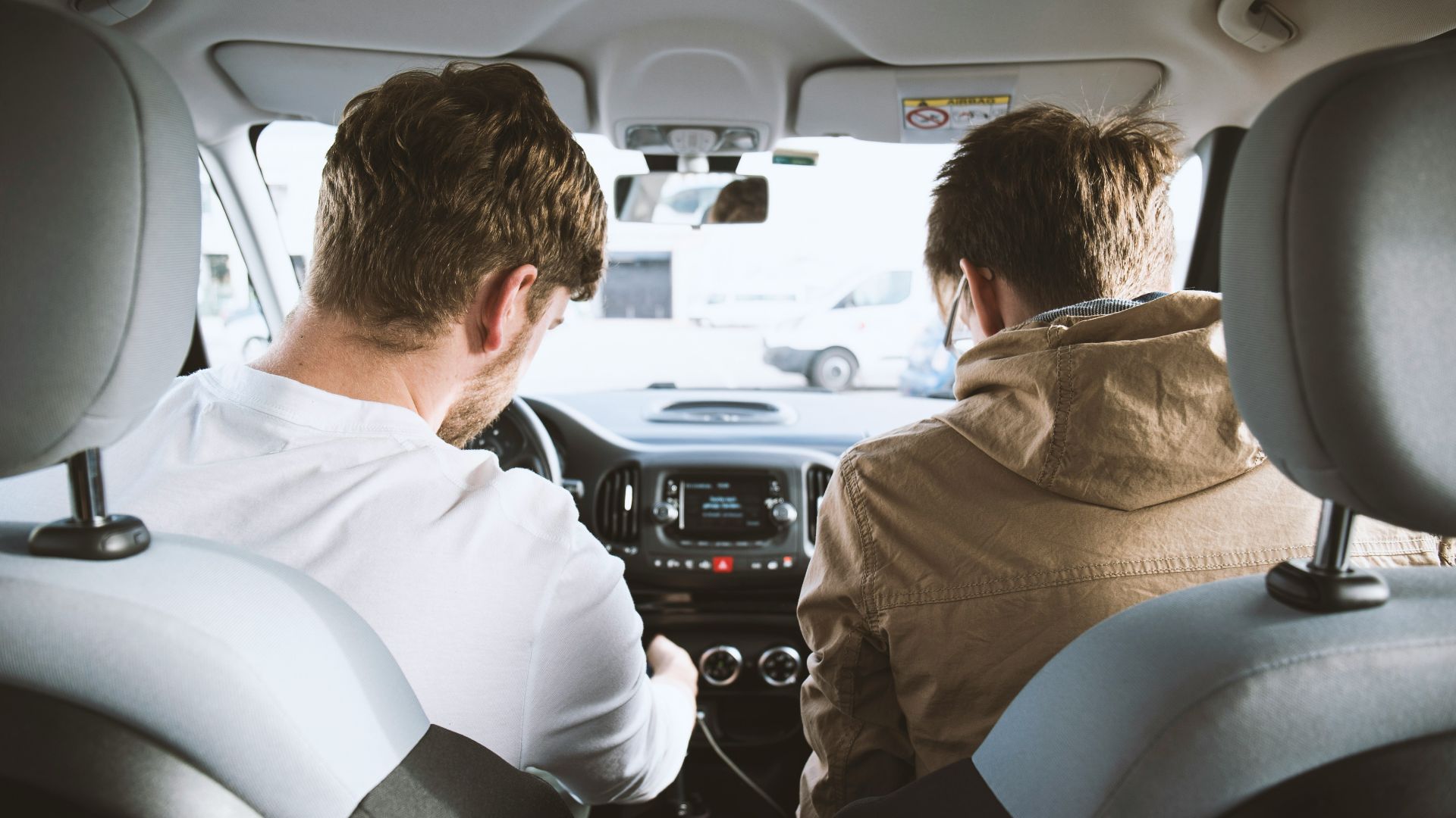two men sitting inside vehicle