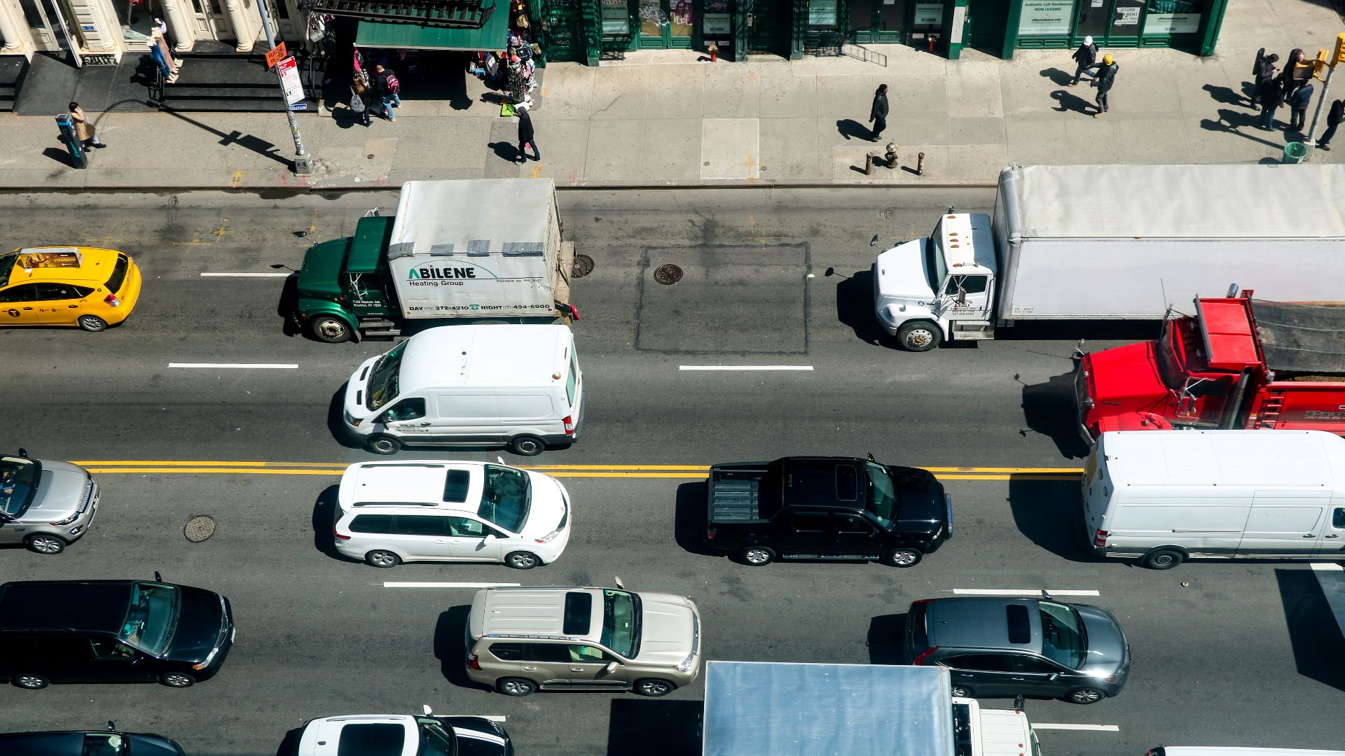 a city street filled with lots of traffic next to tall buildings