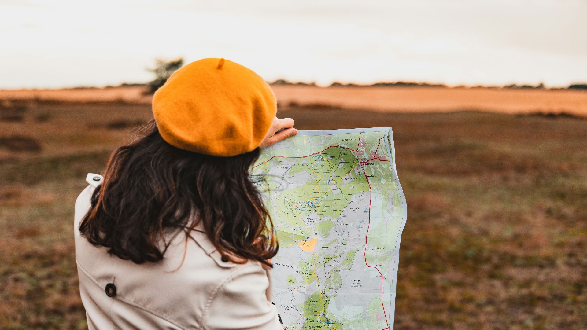 a woman holding a map in a field