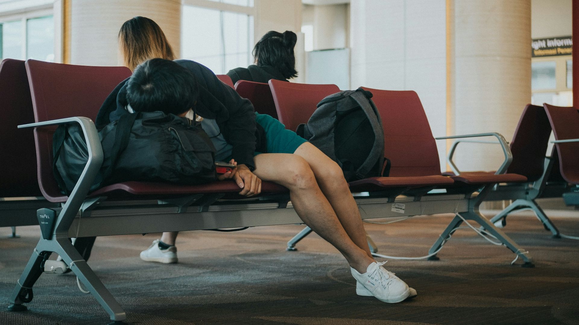unknown person lying on brown bench indoors