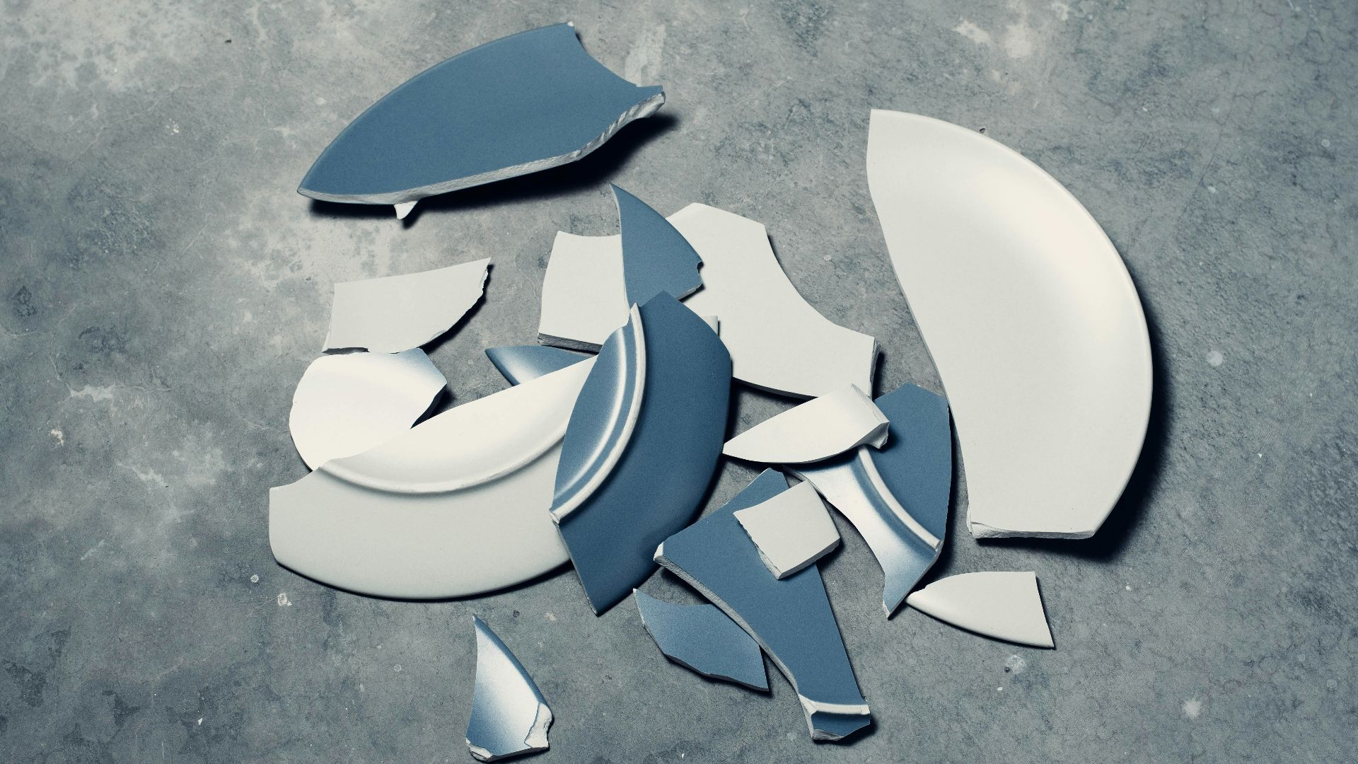 blue broken plate on gray concrete floor