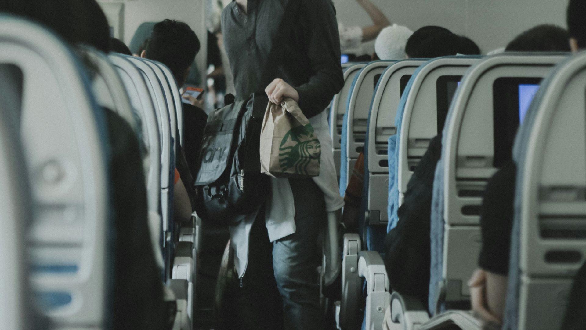 man holding bags inside plane