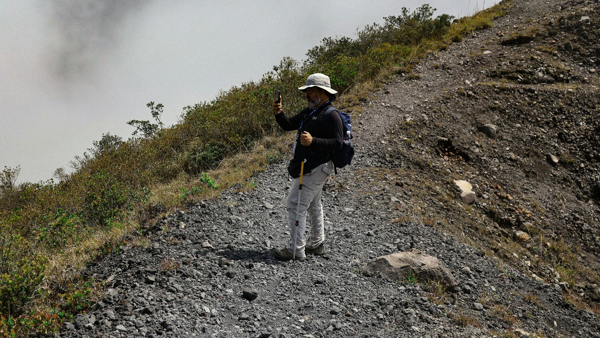 Person poses for a photo on a mountain ridge.