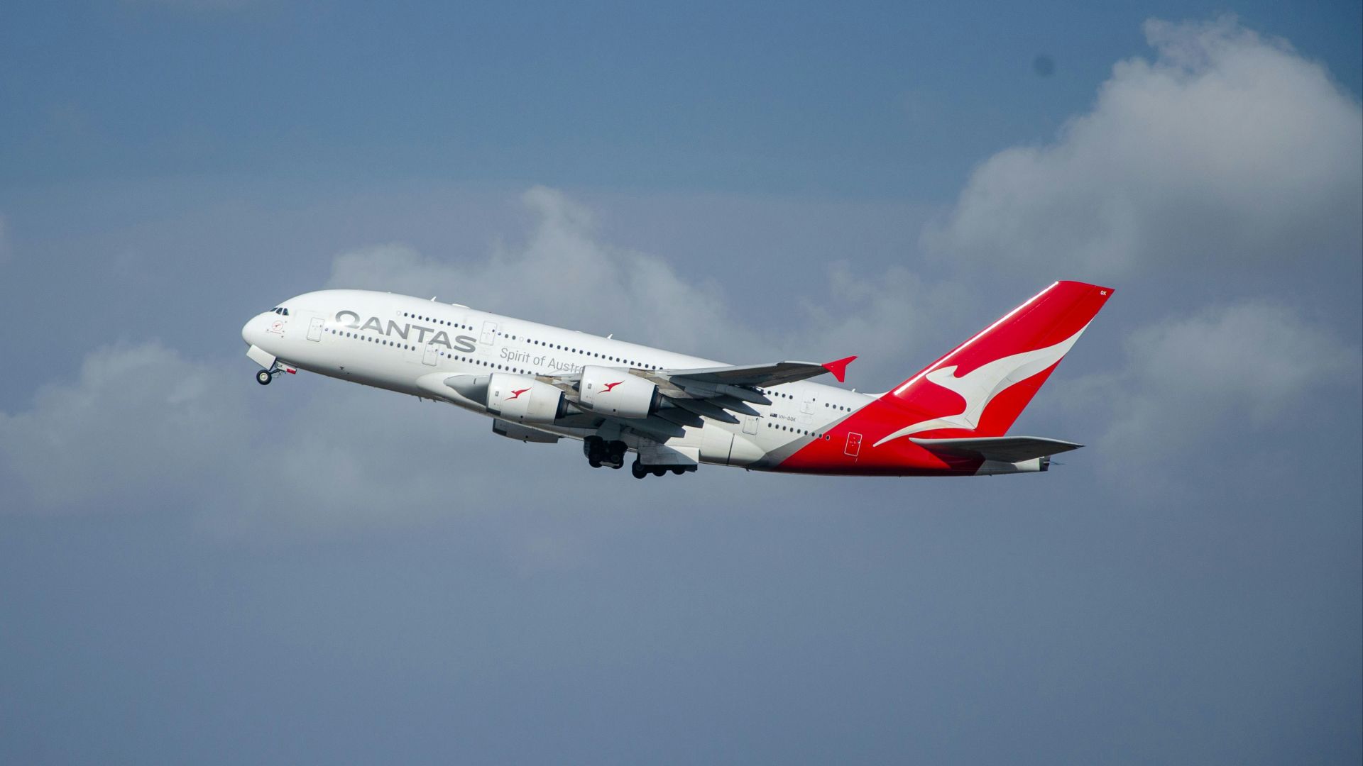 a large passenger jet flying through a cloudy blue sky