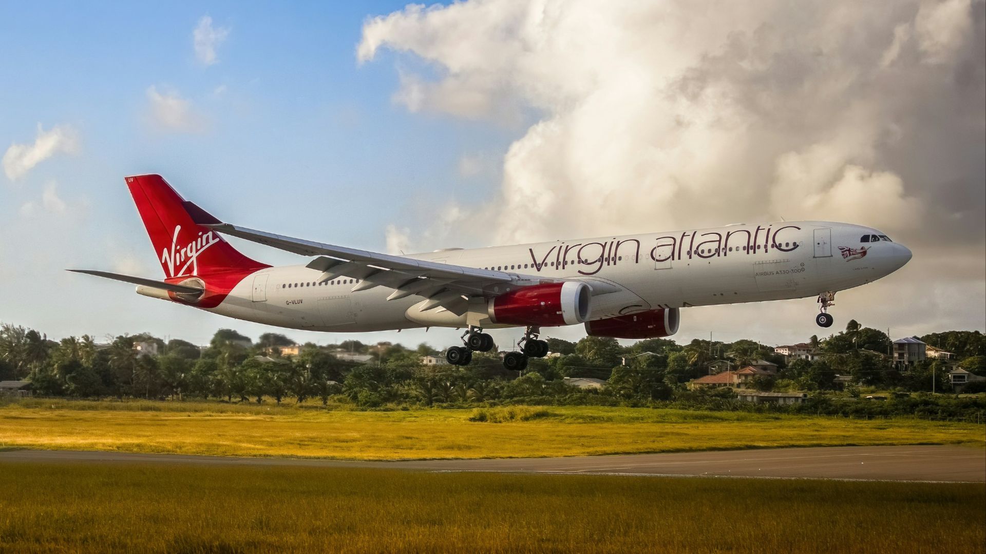 a virgin atlantic airplane taking off from an airport runway