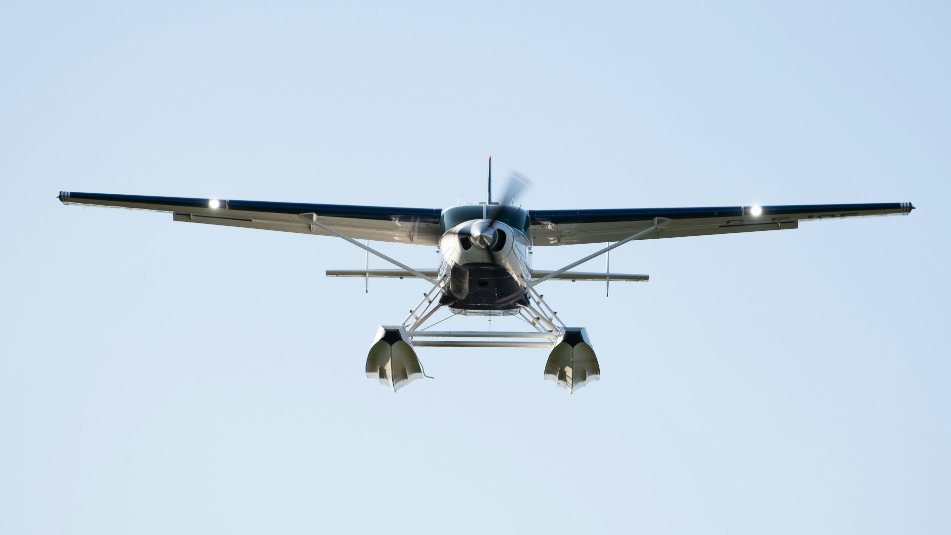 a small propeller plane flying through a blue sky