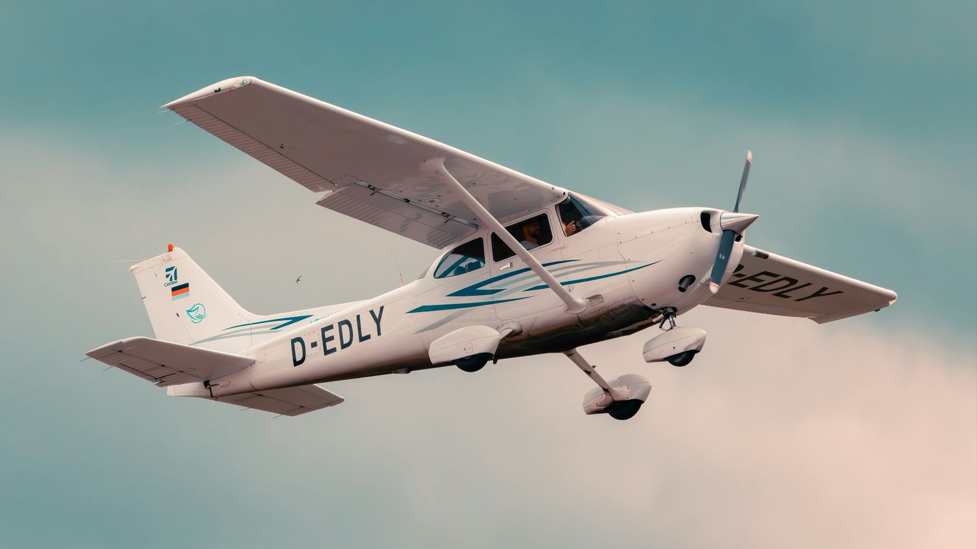 a small airplane flying through a cloudy sky