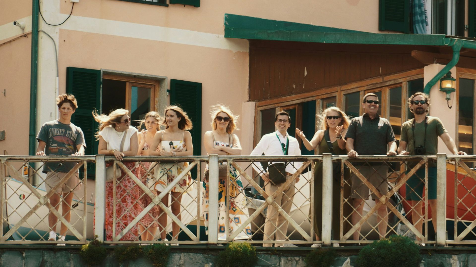A group of people standing on a bridge next to a building