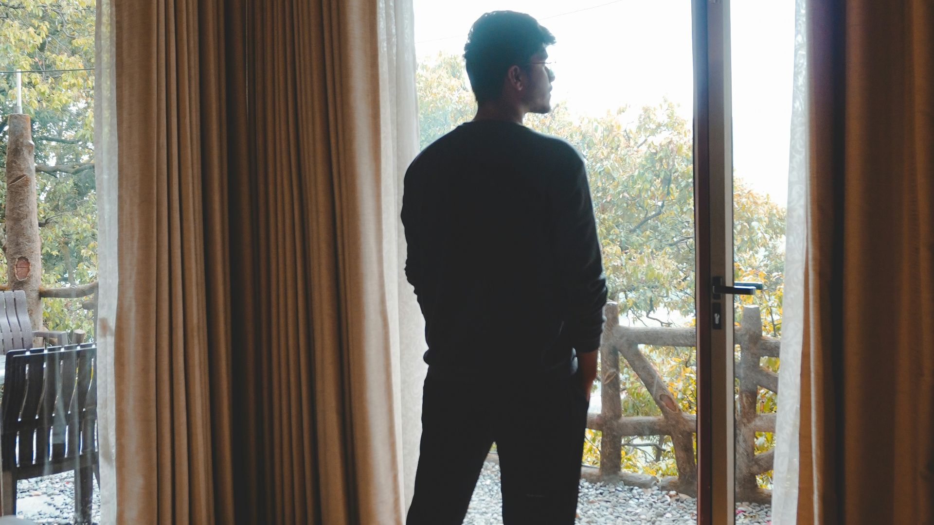 a man standing in front of a sliding glass door