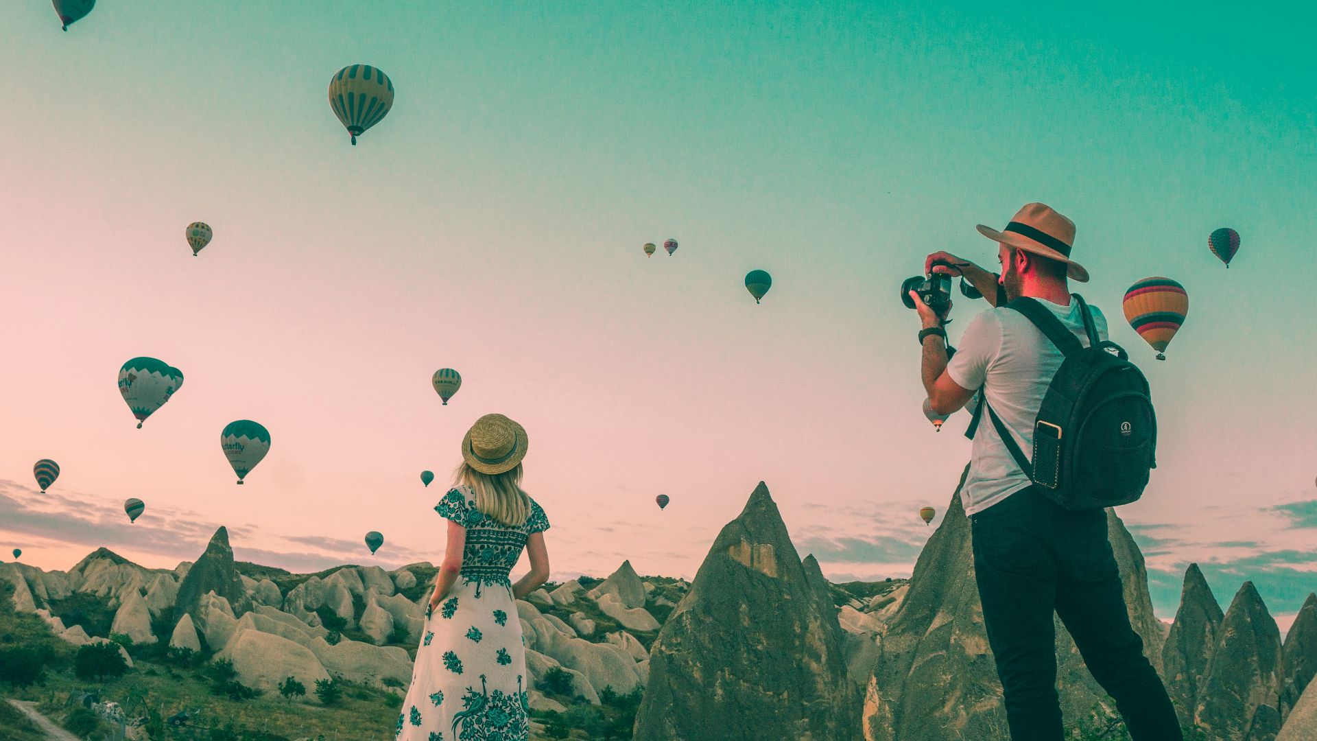 man taking photo of hot air balloons
