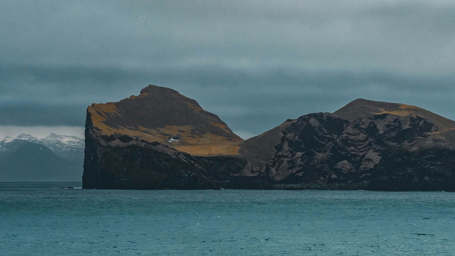A rocky island sits in the vast, blue sea.