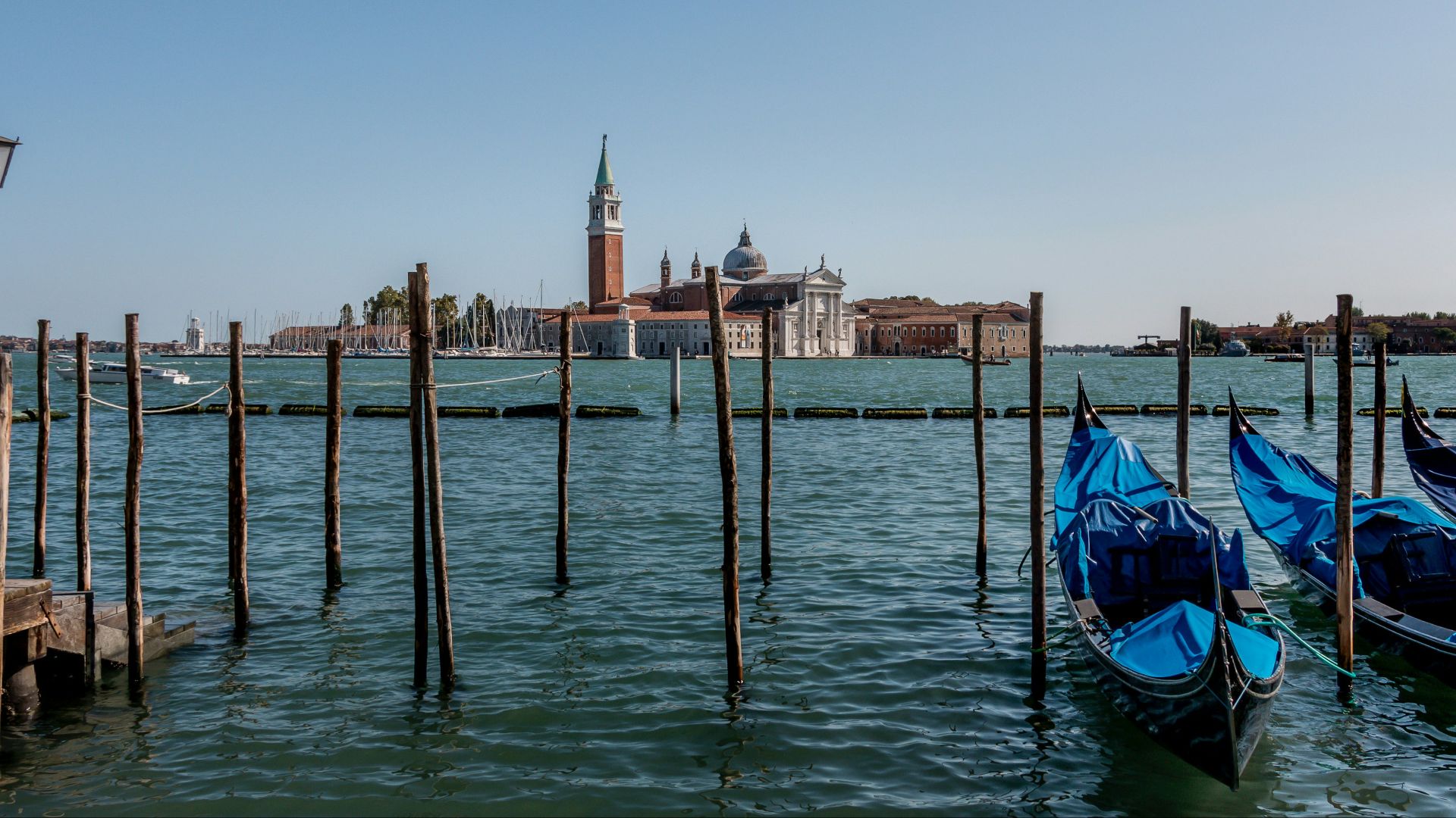 blue and black boat on water near brown concrete building during daytime