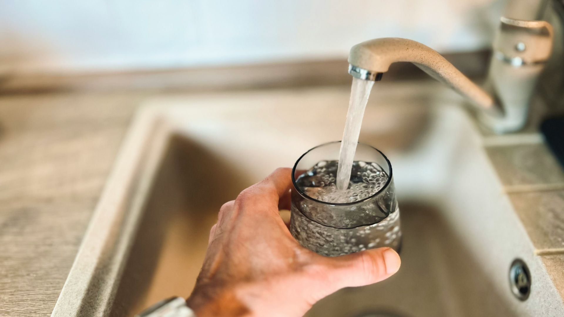 a hand holding a glass of water