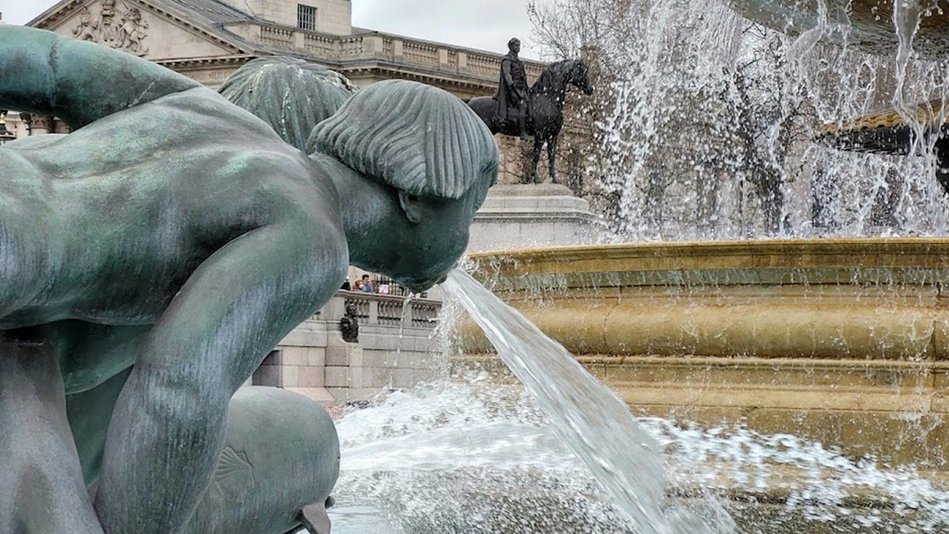 a fountain with a statue in front of a building