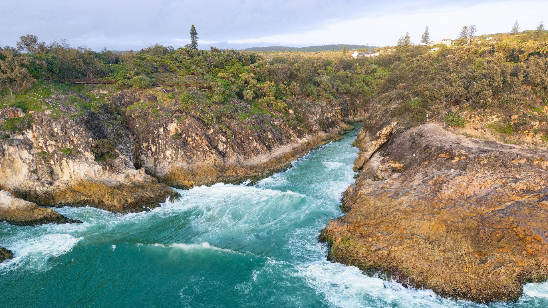 an aerial view of a river flowing between two large rocks