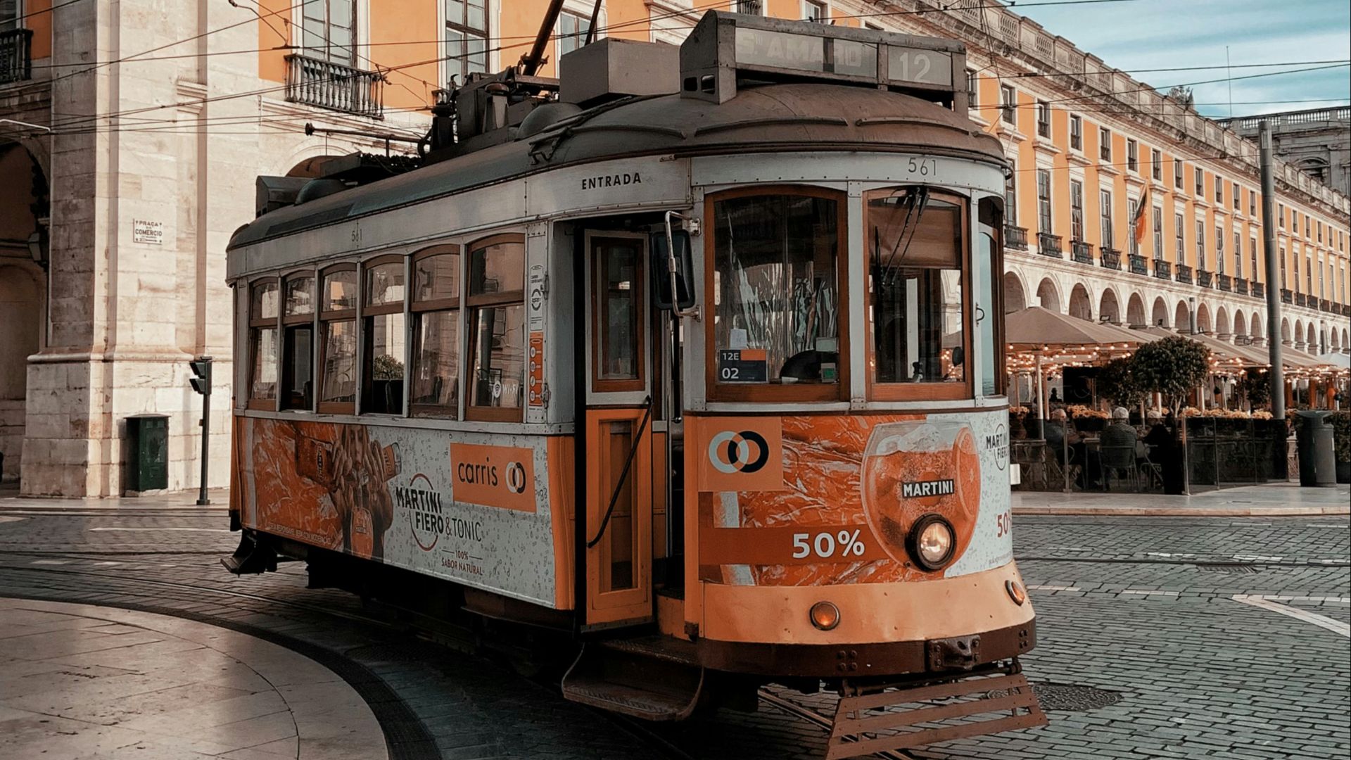 orange and white tram on road near brown concrete building during daytime