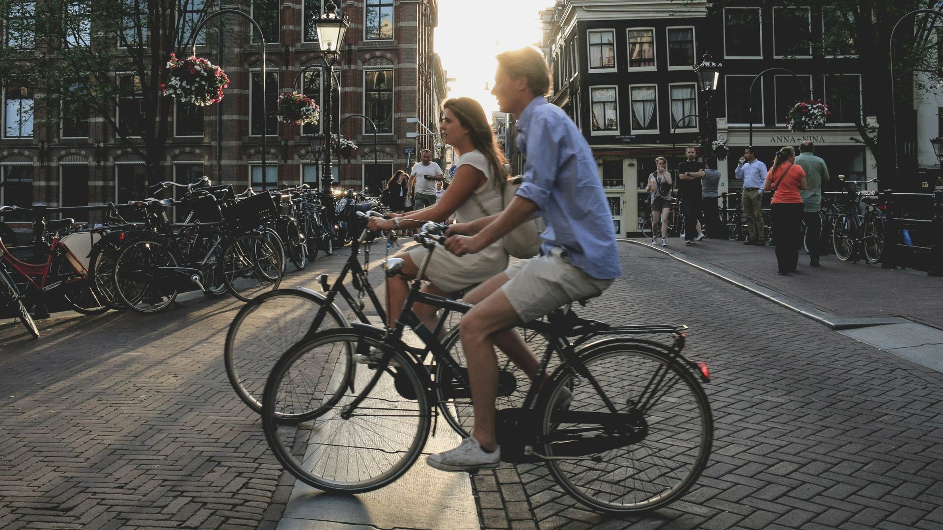 man and woman biking along city at daytime