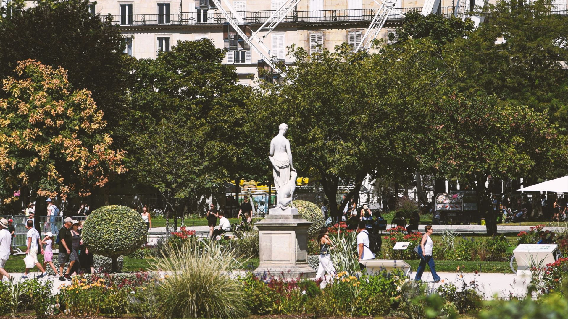 Ferris wheel in a park with people and buildings