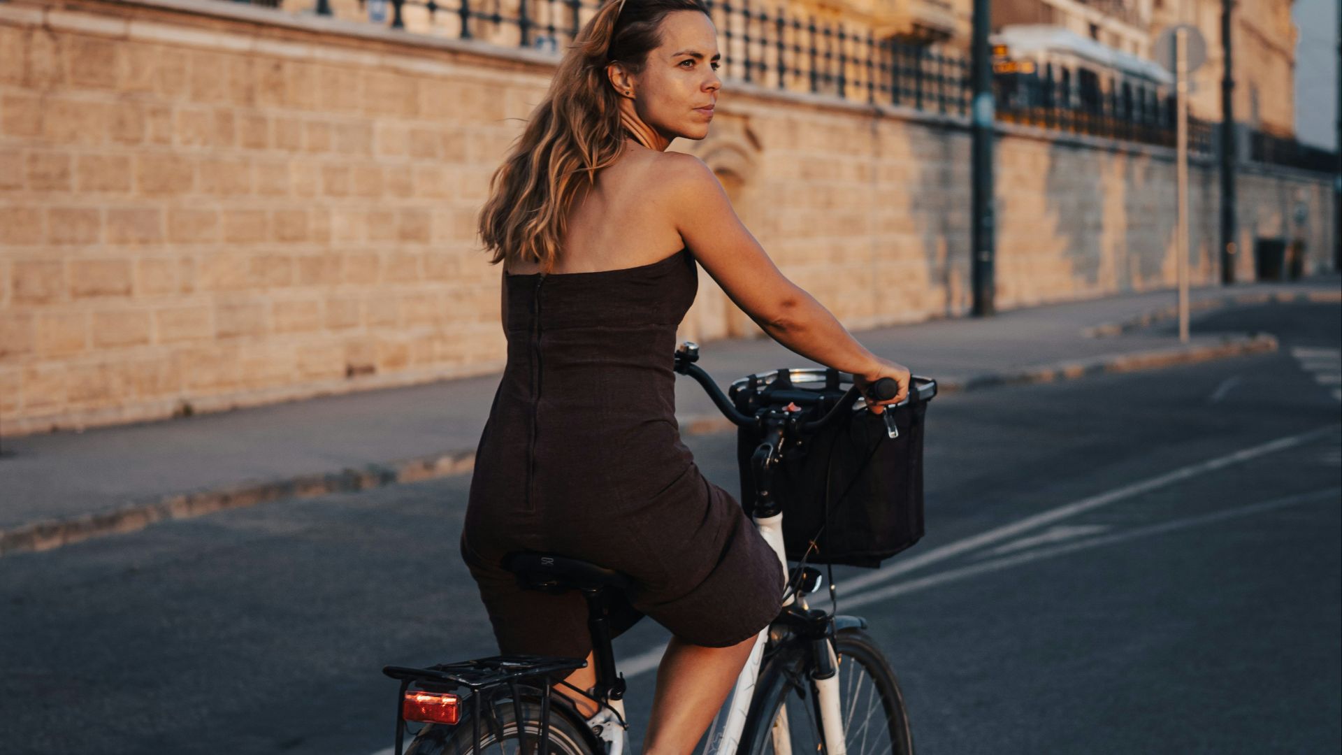 a woman riding a bike down a street