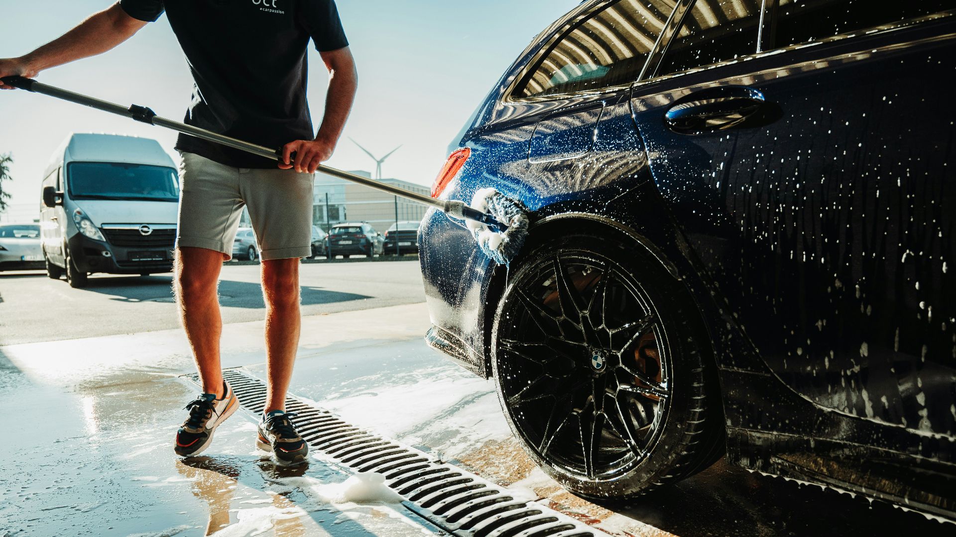 a man is washing a car with a hose