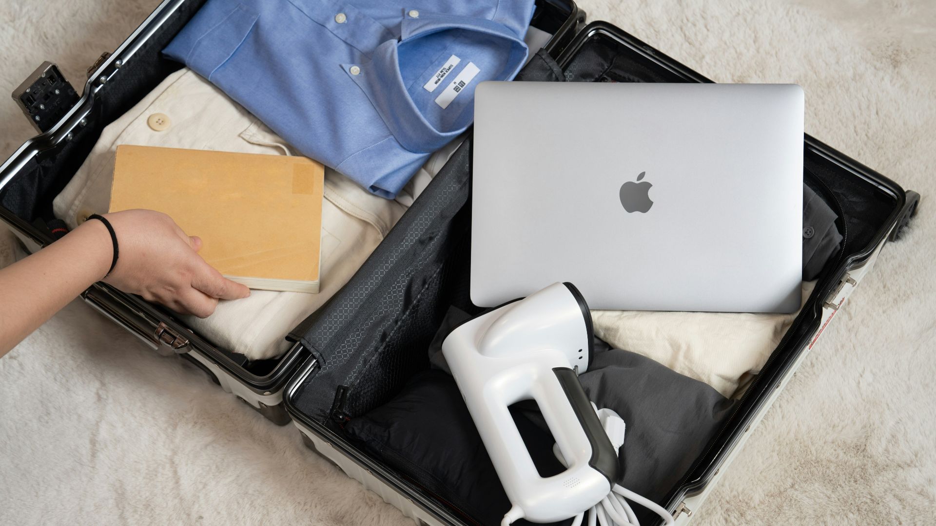 An open suitcase with a laptop and other items