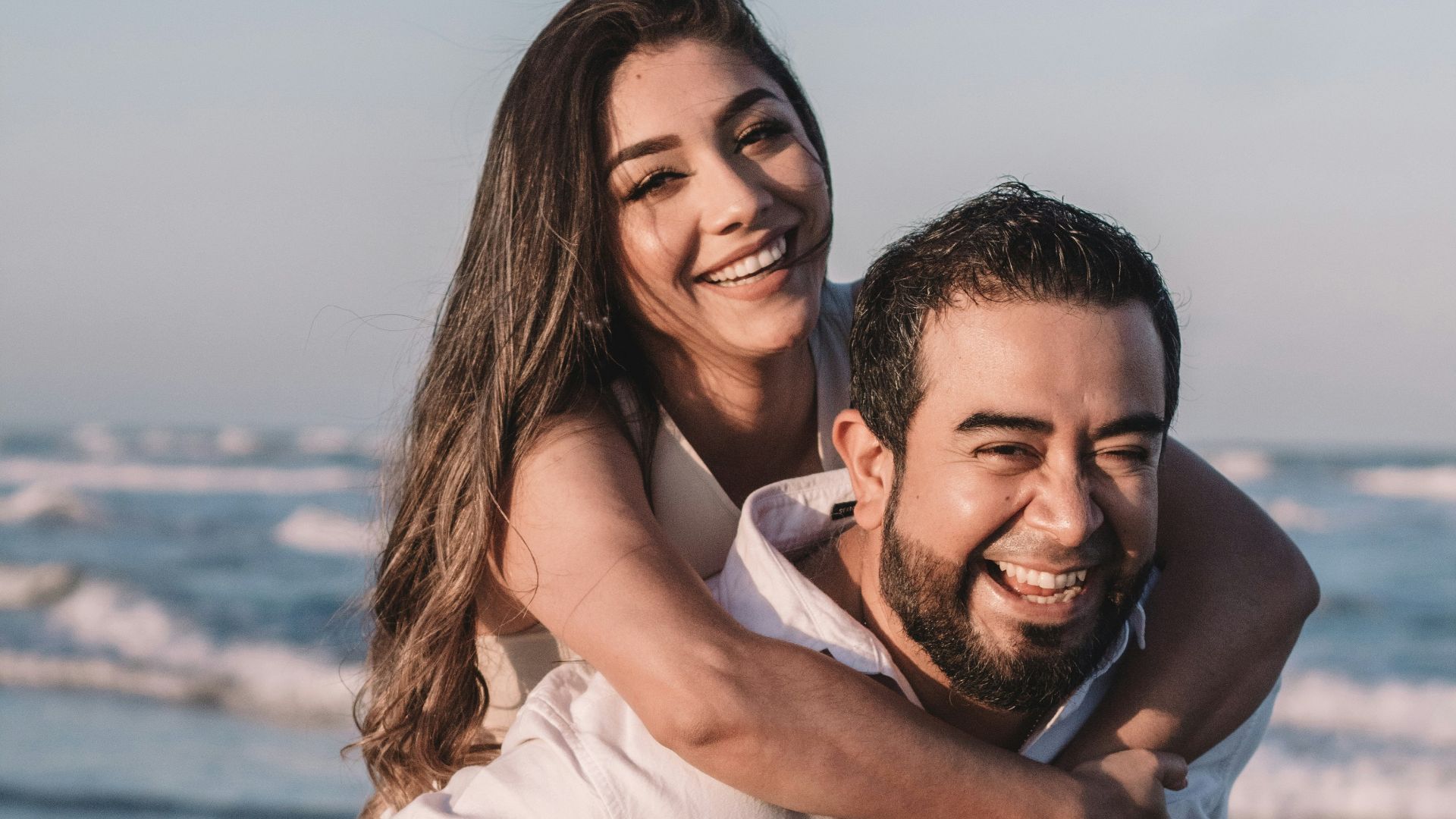 man in white dress shirt hugging woman in white dress
