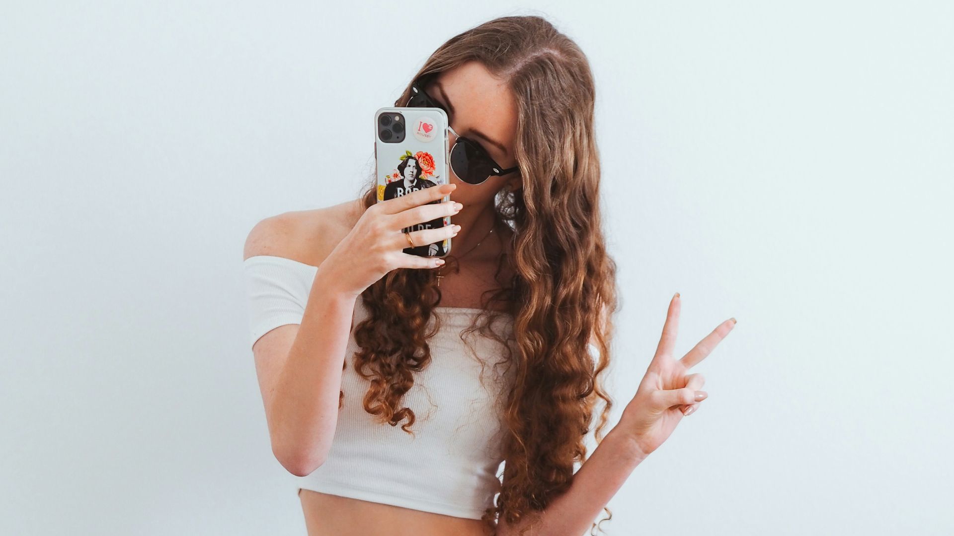 woman in pink tank top and blue denim jeans sitting on yellow chair
