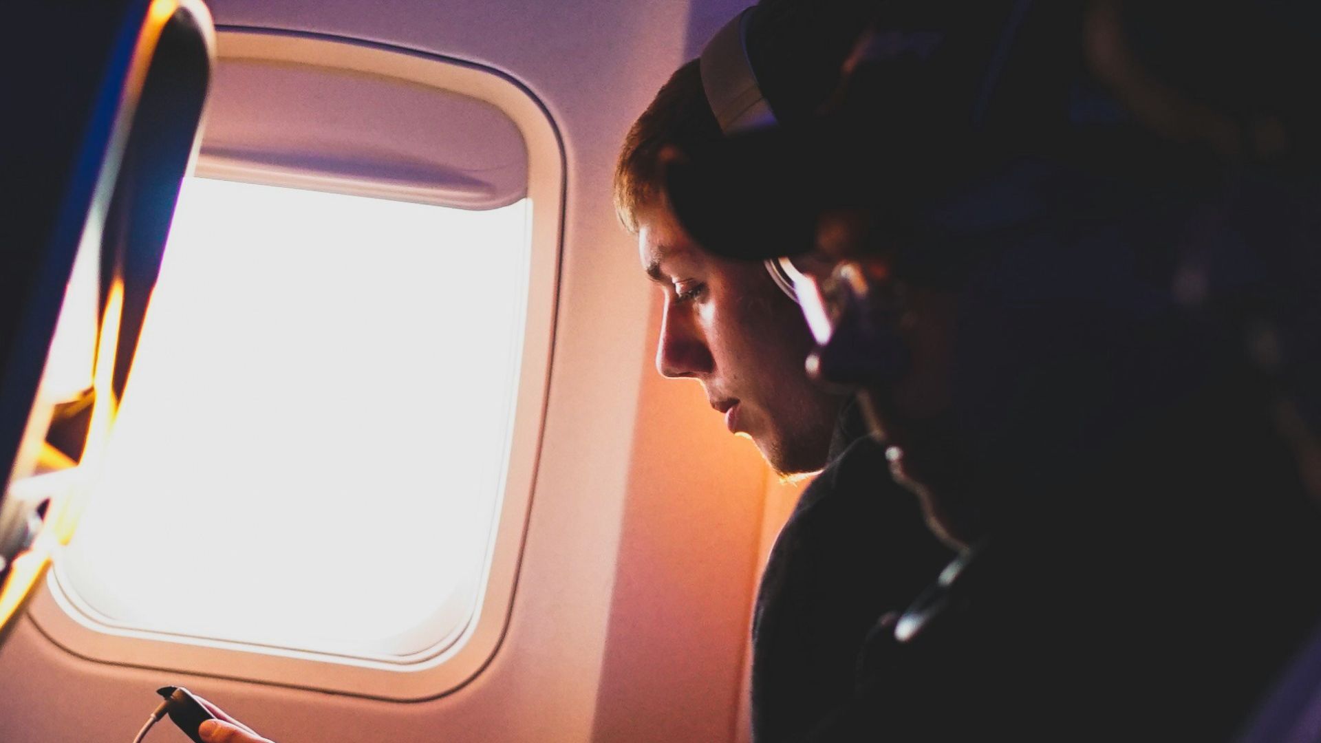 photo of three people listening to music inside airplane