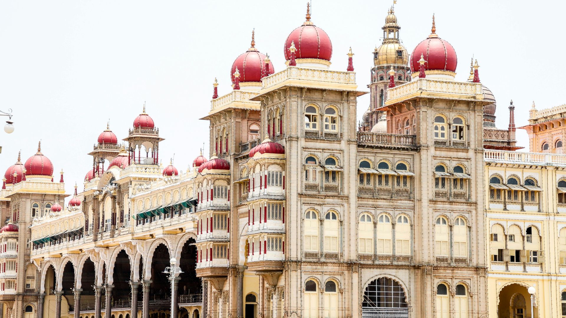 a large building with red domes with Mysore Palace in the background