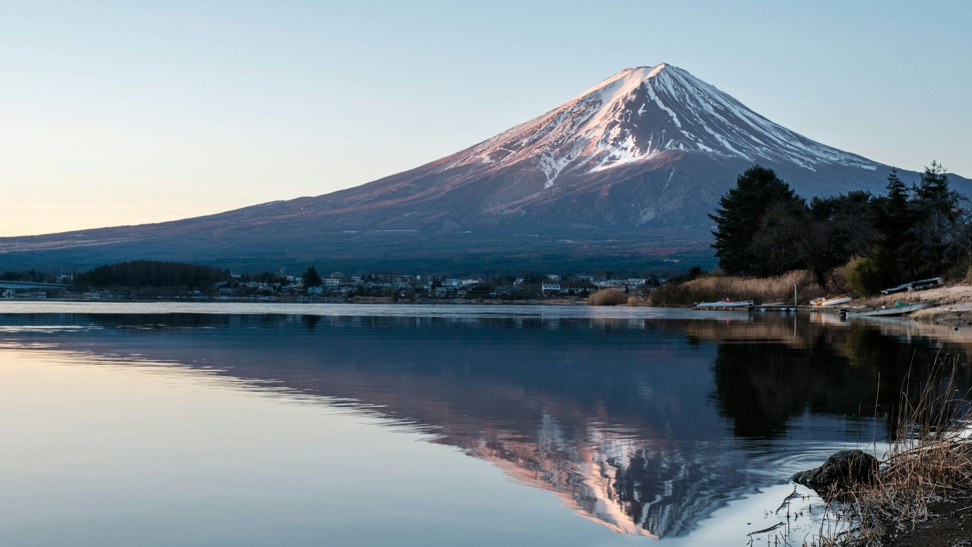 a mountain with snow on top is reflected in a lake