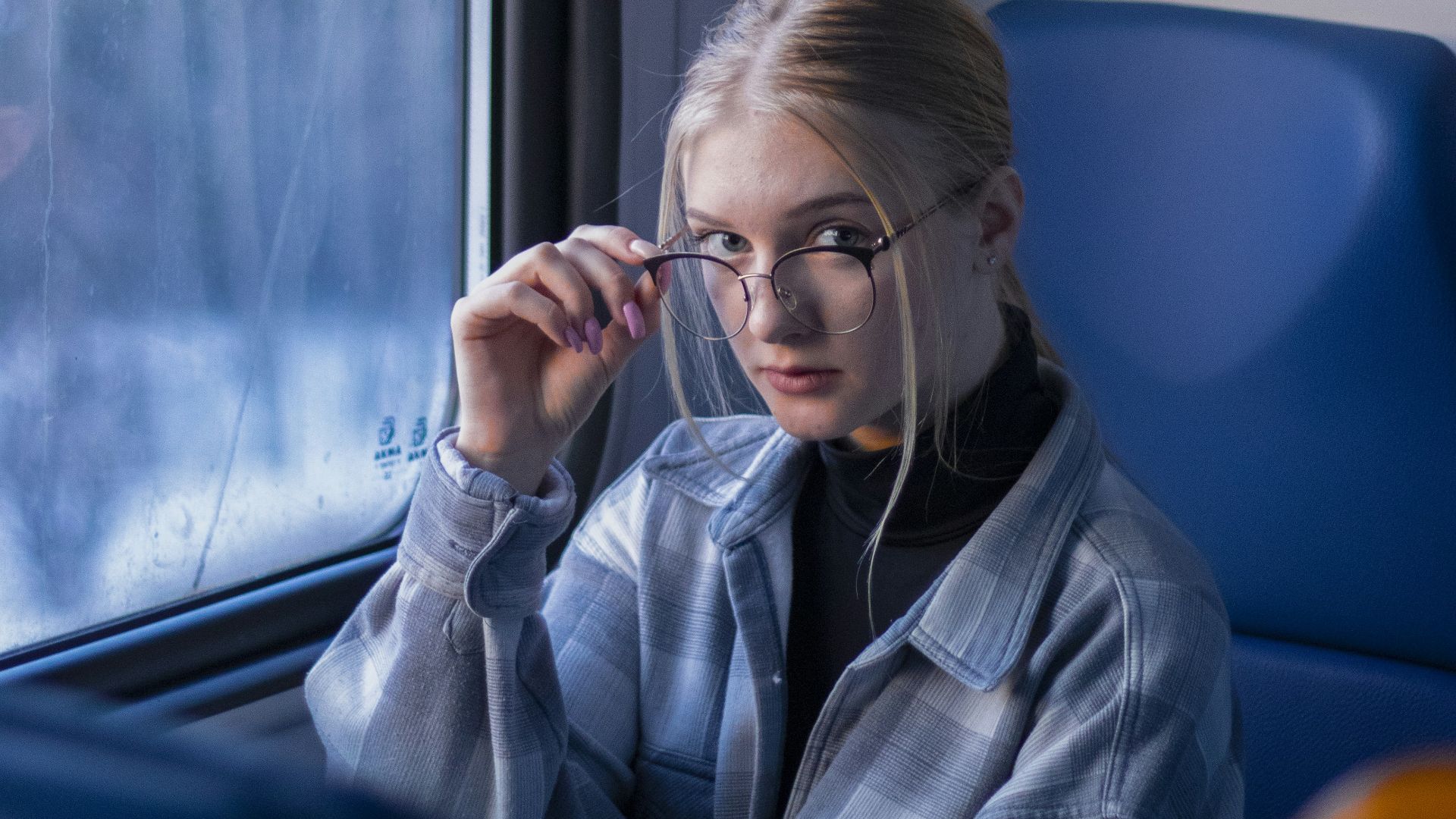 a woman sitting on a train looking out the window