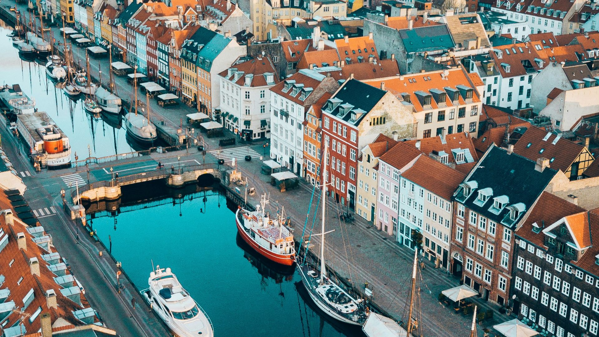 aerial photo of boats in between concrete buildings during daytime