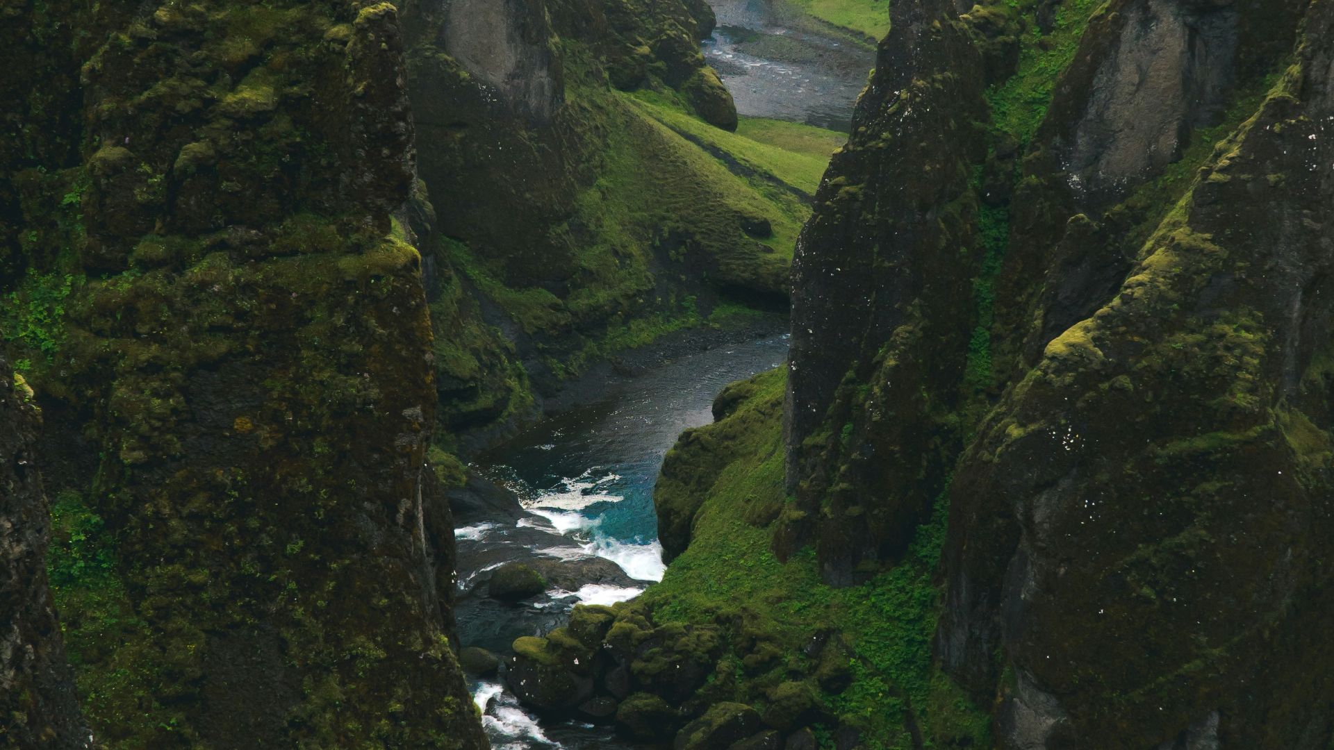 aerial view photography of body of water across green mountains